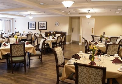 Dining room with neatly set tables and floral centerpieces
