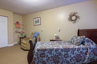 Cozy private resident room with a bed and chair
