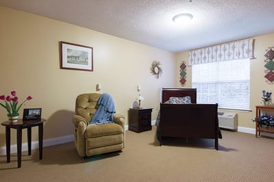 Cozy interior of a resident's room with a chair and bed