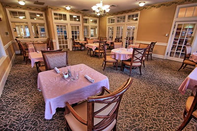Dining room with tables and chairs set for meals
