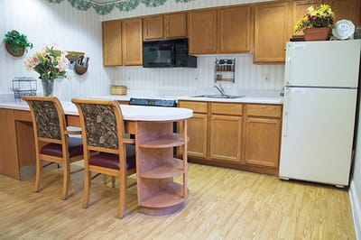 Interior kitchen area with cabinets and dining chairs