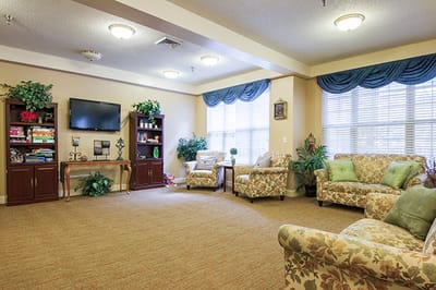 Common area with seating and television in a senior living facility
