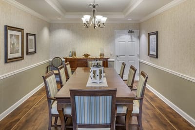 A bright dining area with a long wooden table and chairs