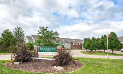 Entrance sign for Brookstone of Aledo with building in background