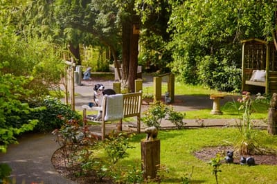 Gardens with benches and a resident enjoying the outdoors