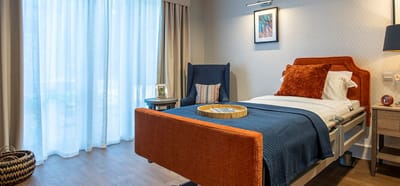 A well-furnished resident room with natural light