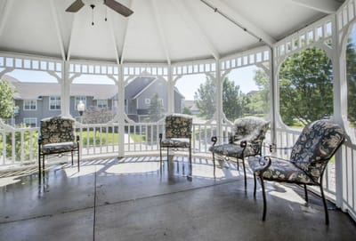 Outdoor seating area with floral chairs in a gazebo