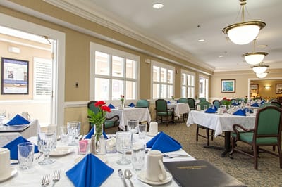 Elegant dining room set for a meal with flowers and cutlery.