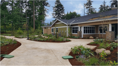 Exterior view of a senior living facility with gardens