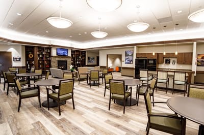Bright communal area with seating and a fireplace