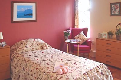 Cozy bedroom with floral bedding and a chair