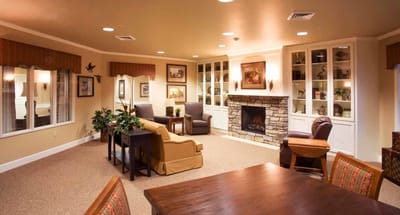Cozy common area in a senior living facility with seating and a fireplace