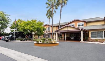 Exterior view of Cypress Place with landscaping and a shuttle.