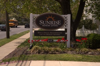 Exterior sign of Sunrise Senior Living with flowers