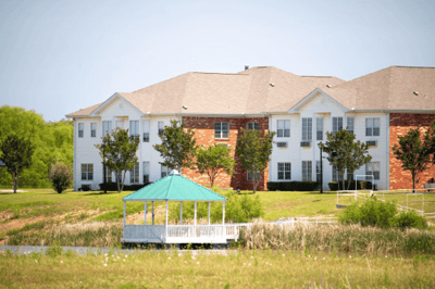 Exterior view of a senior living facility with gazebo