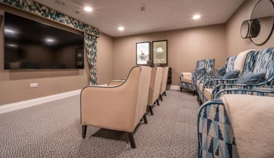 Cozy movie room with plush seating and screen