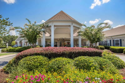 Front entrance of the Oaks at Evans with colorful landscaping