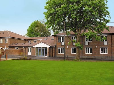Exterior view of Farnham Common House with landscaped area