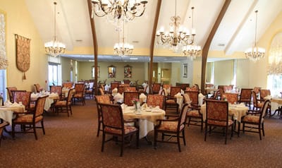 Elegant dining room with chandeliers and tables set for meals