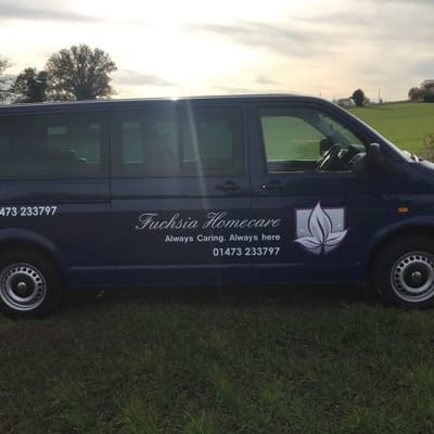 Fuchsia Homecare transport van parked in a grassy area