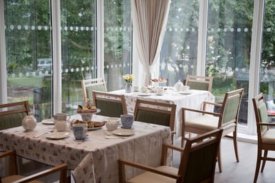 Dining room set up for a meal with flowers and tableware