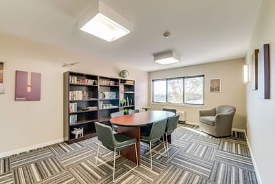 Bright common area with bookshelves and a meeting table