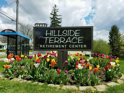 Sign for Hillside Terrace Retirement Center surrounded by flowers
