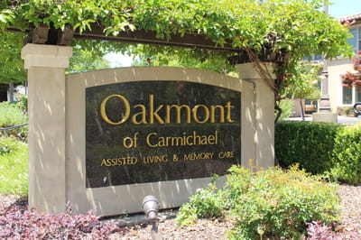 Sign for Oakmont of Carmichael with greenery