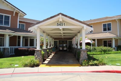 Entrance of a senior living facility with covered seating area