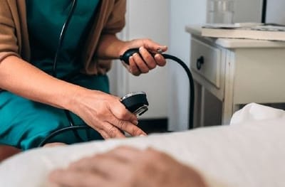 Nurse taking a resident's blood pressure in a room