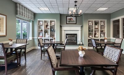 Bright common area with tables and a fireplace