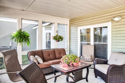 Covered outdoor seating area with plants and furniture