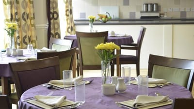 Dining room setup with flowers and table settings
