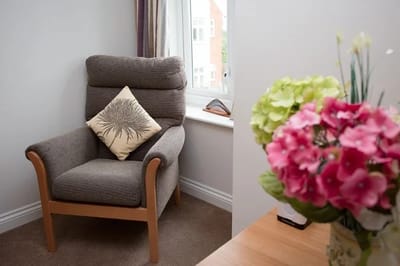 Cozy seating area with a floral cushion and flowers