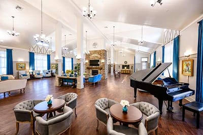 Bright and spacious common area with seating and piano