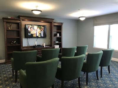 Common area with green chairs and a television