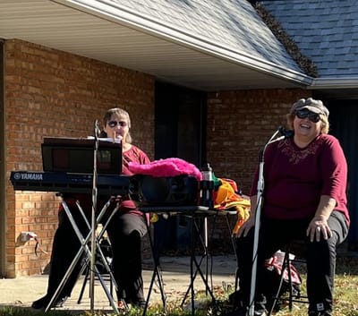 Two performers entertaining residents outdoors at the facility.