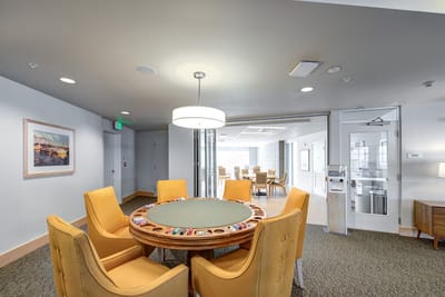 Interior common area with a round table and yellow chairs