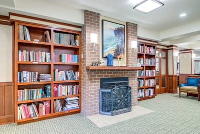 Cozy common area with bookshelves and a fireplace