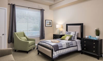 Cozy private resident room with a bed and chair