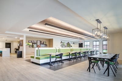 Bright dining area with green seating and modern design