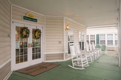 Covered porch with rocking chairs and welcome sign