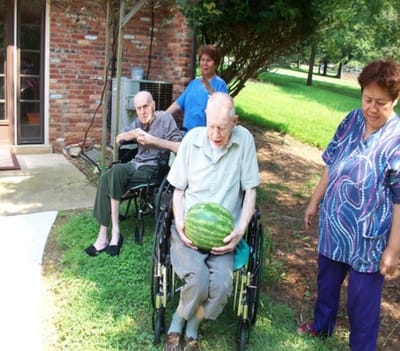 Residents enjoying time outdoors with a watermelon.