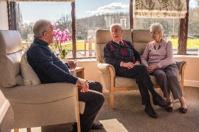 Residents enjoying conversation in a sunny common area
