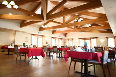 Spacious dining room with red tablecloths and large windows