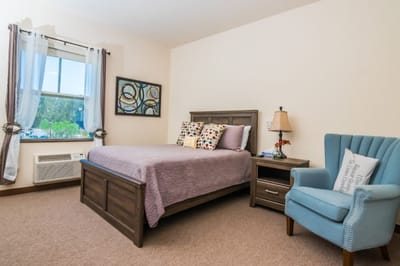 Cozy resident room with bed and chair