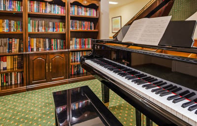 Piano in a library area with bookshelves