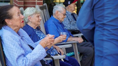 Residents enjoying time outdoors in rocking chairs