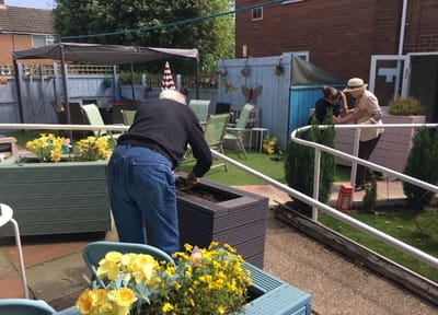 Residents gardening in a sunny outdoor space