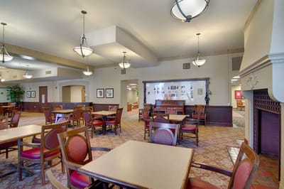 Common area with tables and chairs in a senior living facility